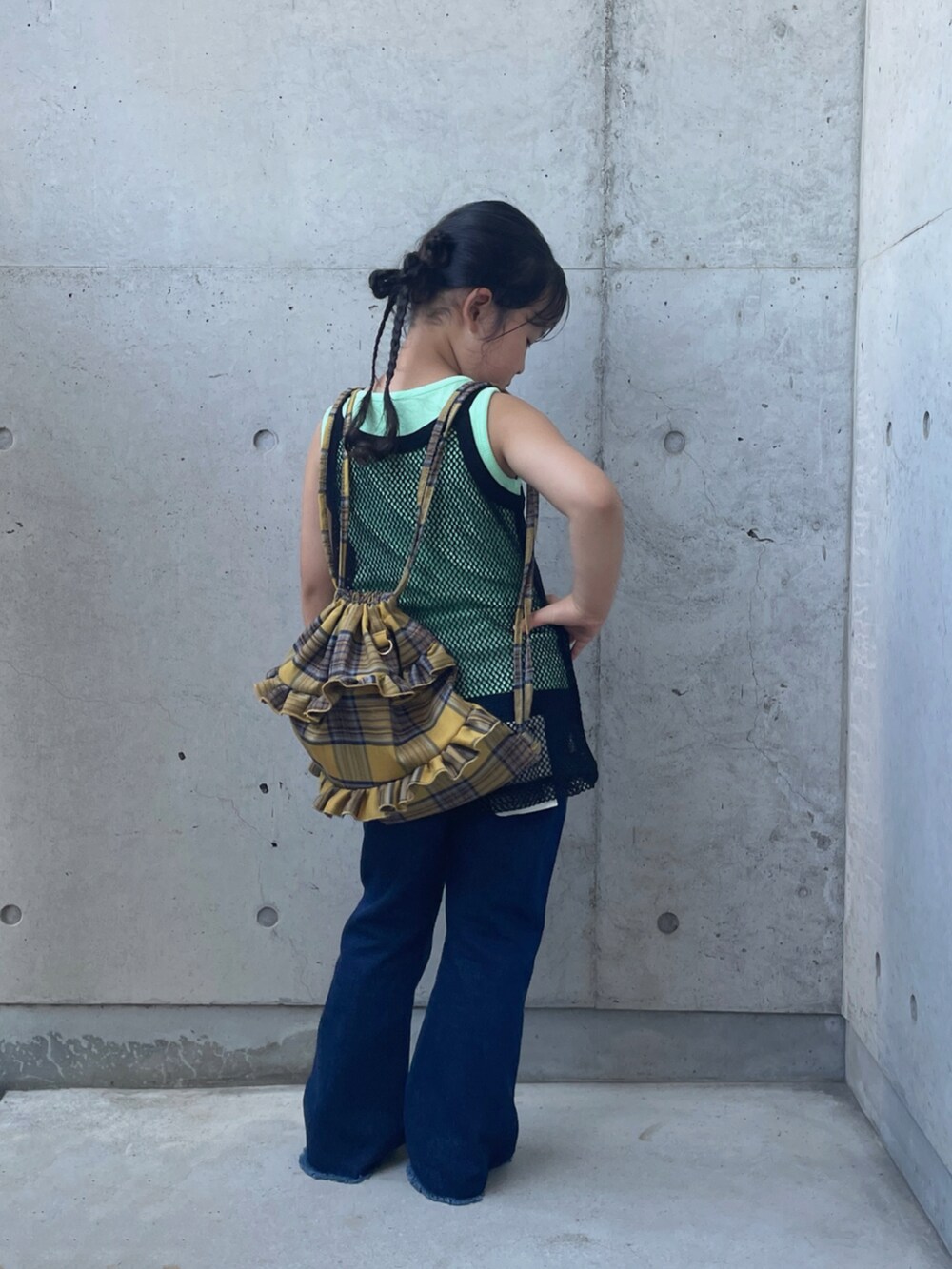 ブラック系のタンクトップ、ブルー系のデニムパンツ、イエロー系のバックパック/リュックを着用したキッズの夏コーディネートの3枚目の写真