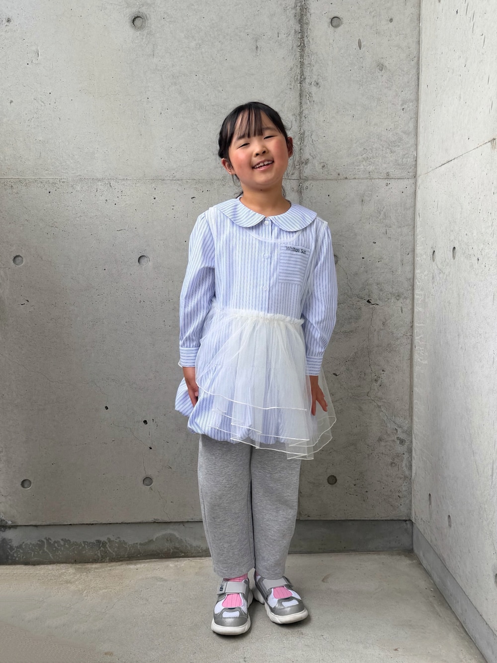 ブルー系のシャツ/ブラウス、ホワイト系のTシャツ/カットソー、シルバー系のスニーカーを着用したキッズの春コーディネートの3枚目の写真