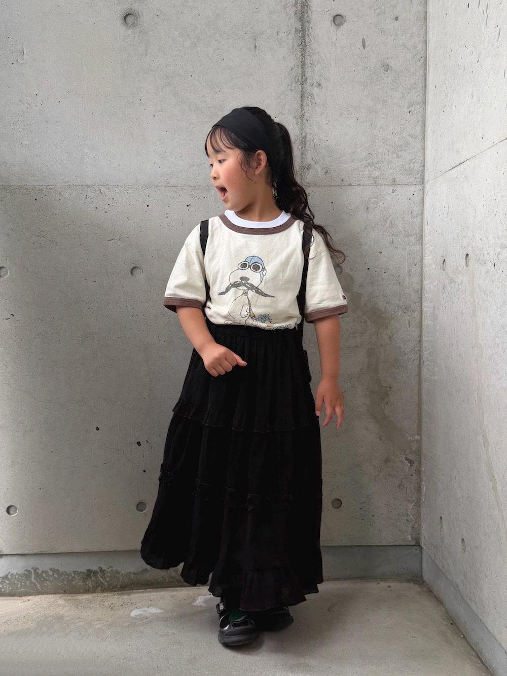 ホワイト系のTシャツ/カットソー、ブラック系のスカート、ブラック系のバックパック/リュックを着用したキッズの夏コーディネートの4枚目の写真
