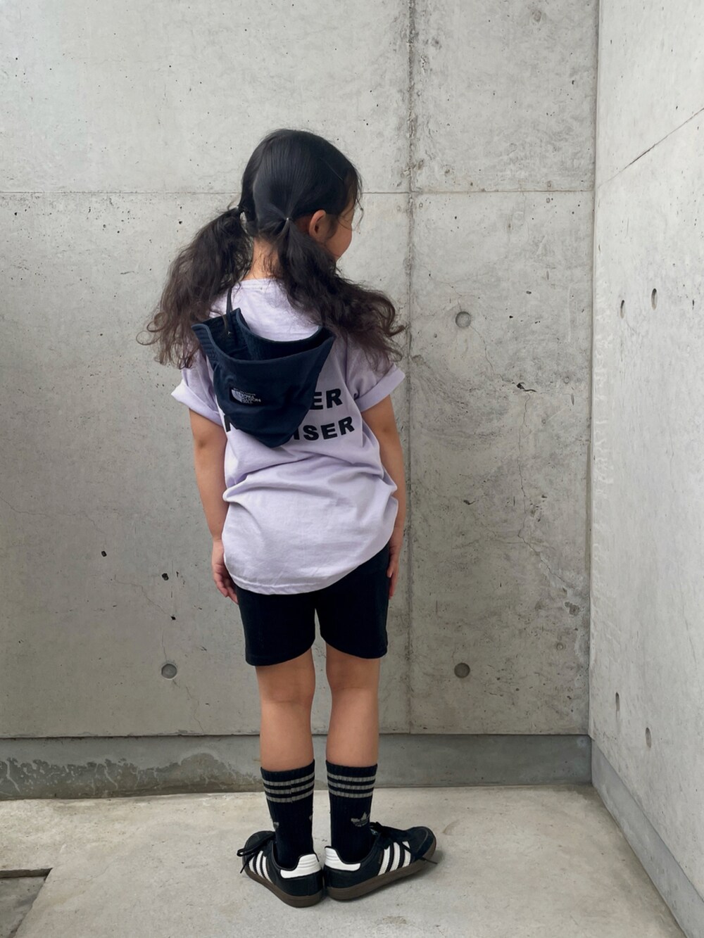 ブラック系のスニーカー、ブラック系のその他パンツ、パープル系のTシャツ/カットソーを着用したキッズの春コーディネートの3枚目の写真