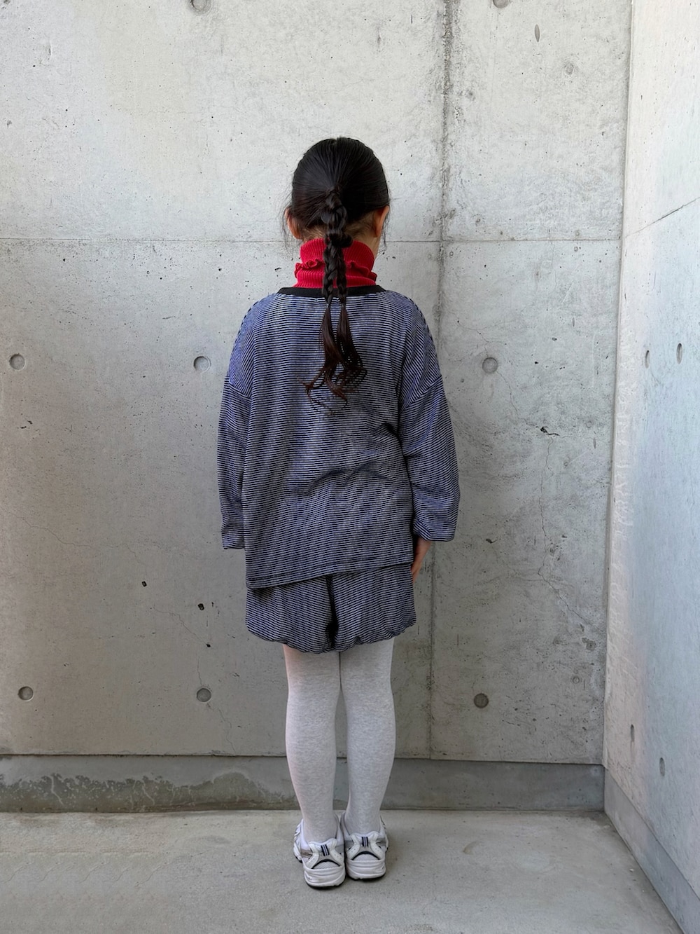 ブラック系のTシャツ/カットソー、レッド系のニット/セーター、ブラック系のその他パンツを着用したキッズの冬コーディネートの5枚目の写真