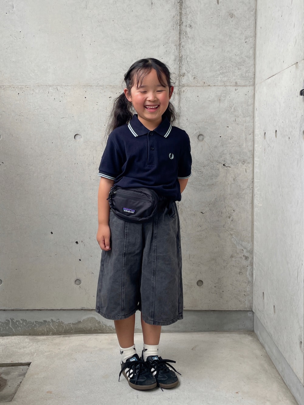 ブラック系のデニムパンツ、ブラック系のスニーカー、ブルー系のポロシャツを着用したキッズの夏コーディネートの3枚目の写真