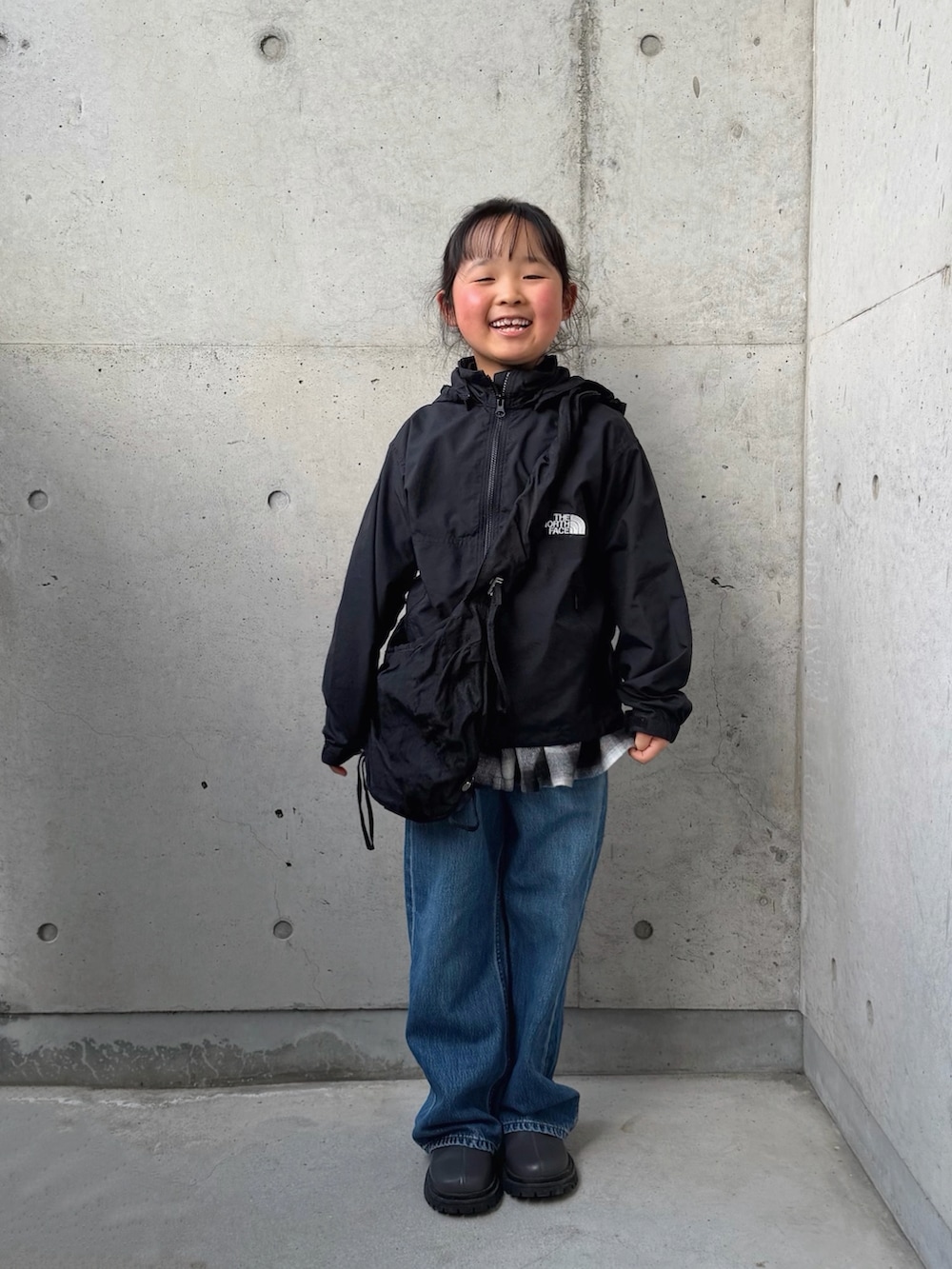 ブラック系のスカート、グレー系のブーツ、ブラック系のマウンテンパーカーを着用したキッズの春コーディネートの4枚目の写真