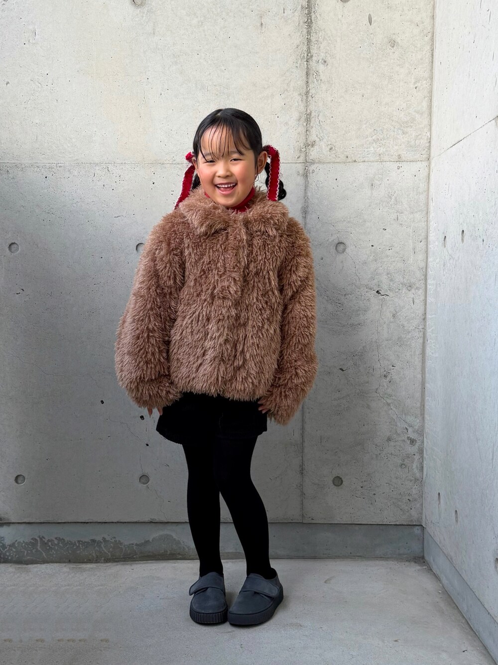 レッド系のニット/セーター、ブラック系のその他パンツ、ブラウン系のブルゾンを着用したキッズの冬コーディネートの5枚目の写真