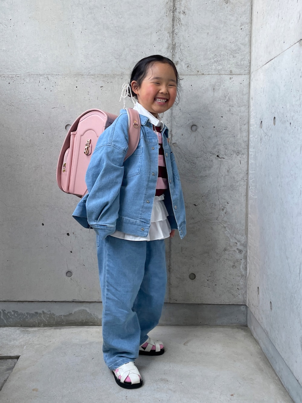 ブルー系のデニムジャケット、ブルー系のデニムパンツ、ピンク系のTシャツ/カットソーを着用したキッズの春コーディネートの2枚目の写真