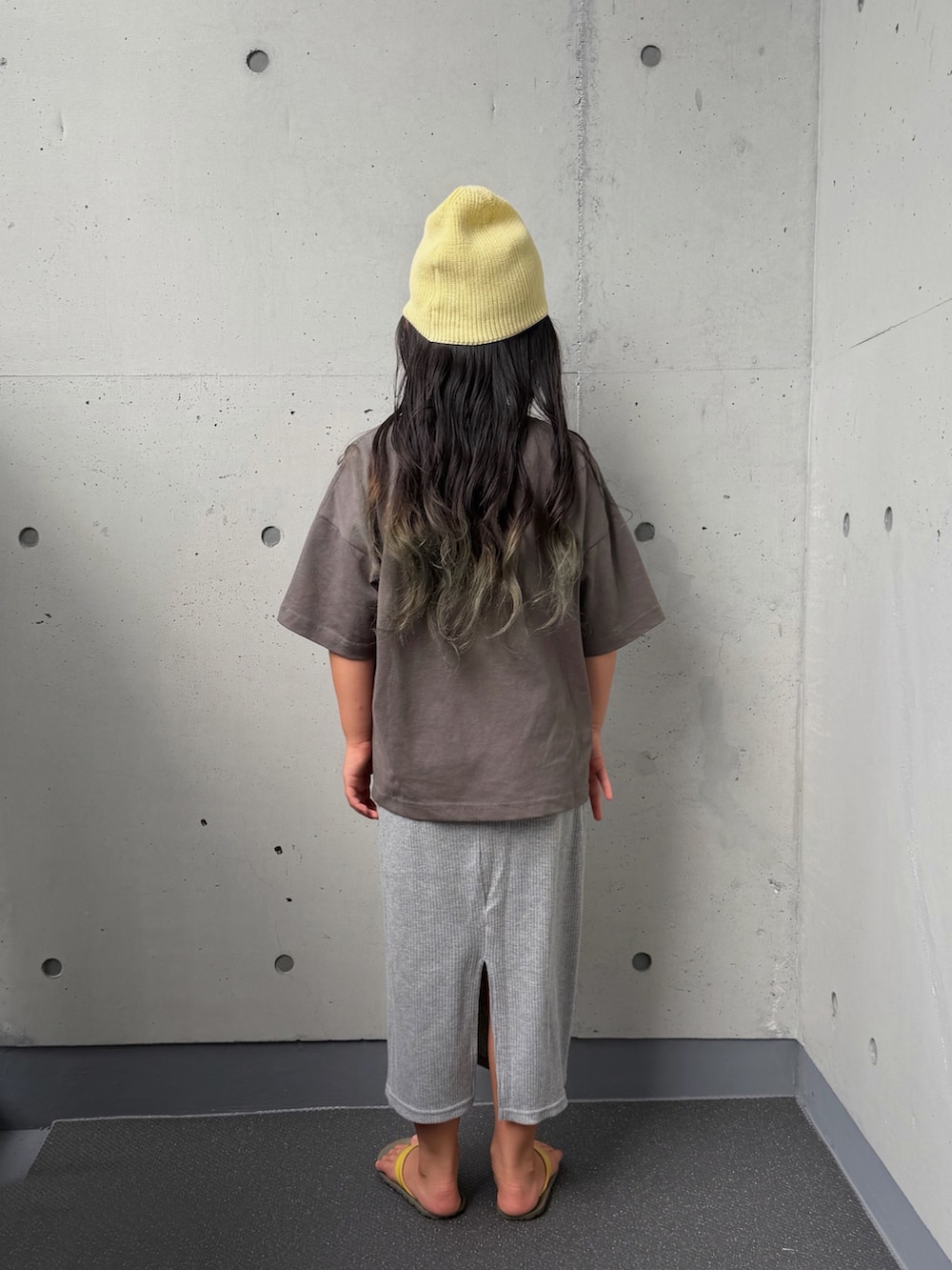 ブラック系のTシャツ/カットソー、グレー系のスカート、ブラウン系のサンダルを着用したキッズの夏コーディネートの2枚目の写真