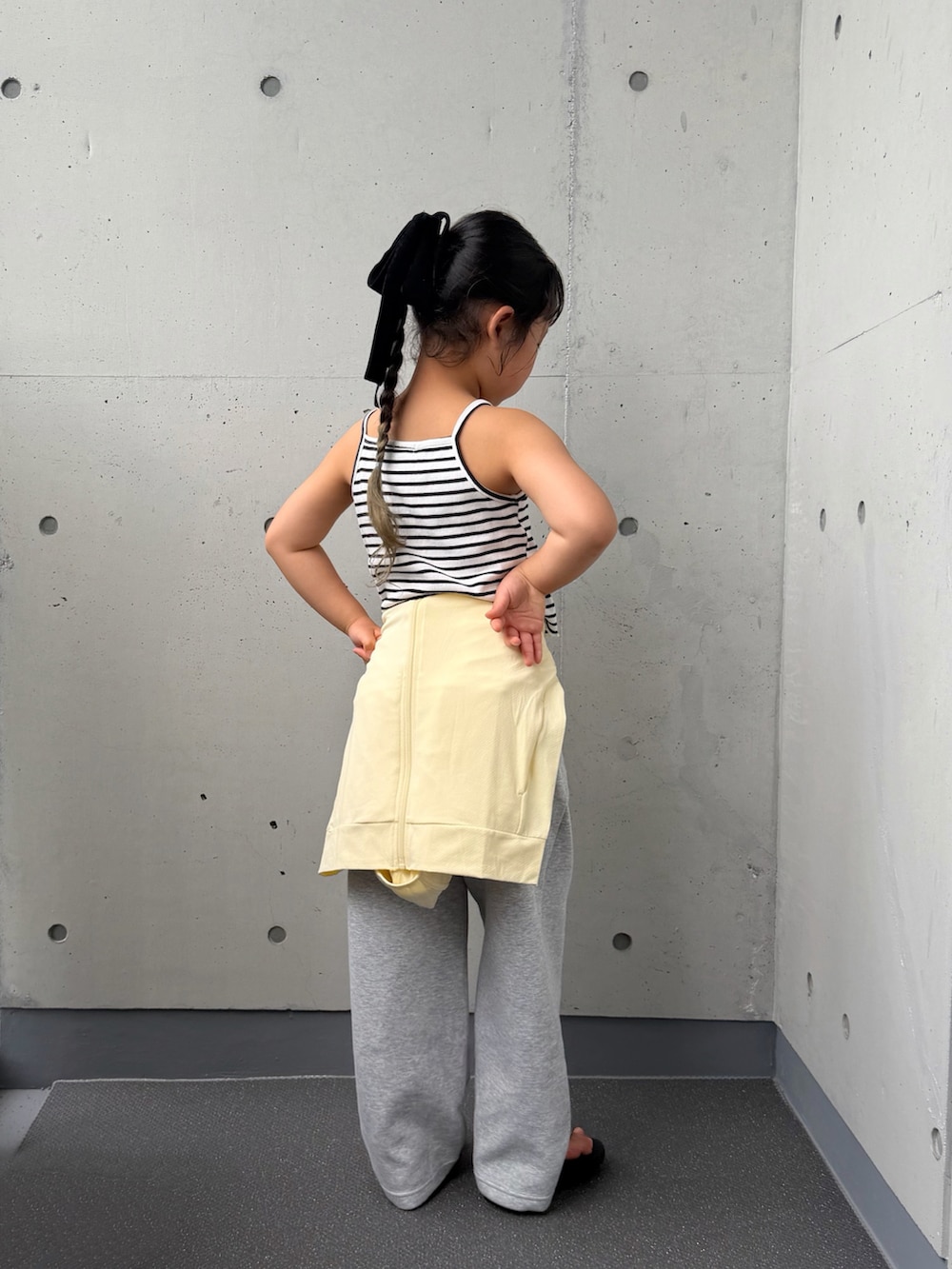 ホワイト系のキャミソール、ブラック系のサンダル、イエロー系のジャケット/アウターを着用したキッズの夏コーディネートの2枚目の写真