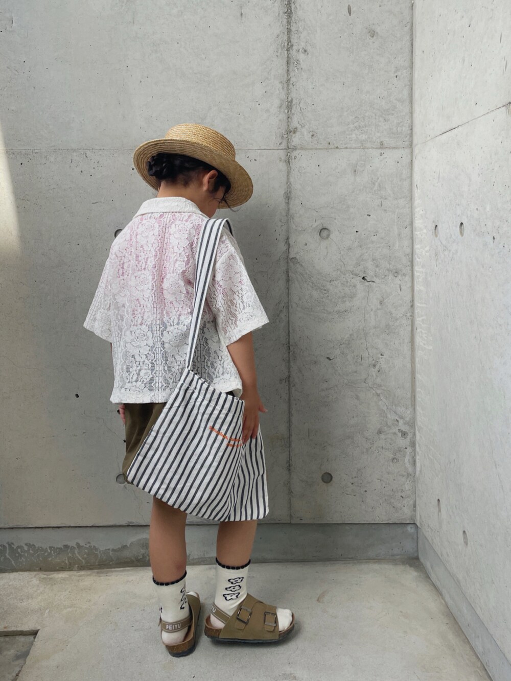 レッド系のTシャツ/カットソー、ホワイト系のシャツ/ブラウス、グリーン系のスカートを着用したキッズの春コーディネートの5枚目の写真