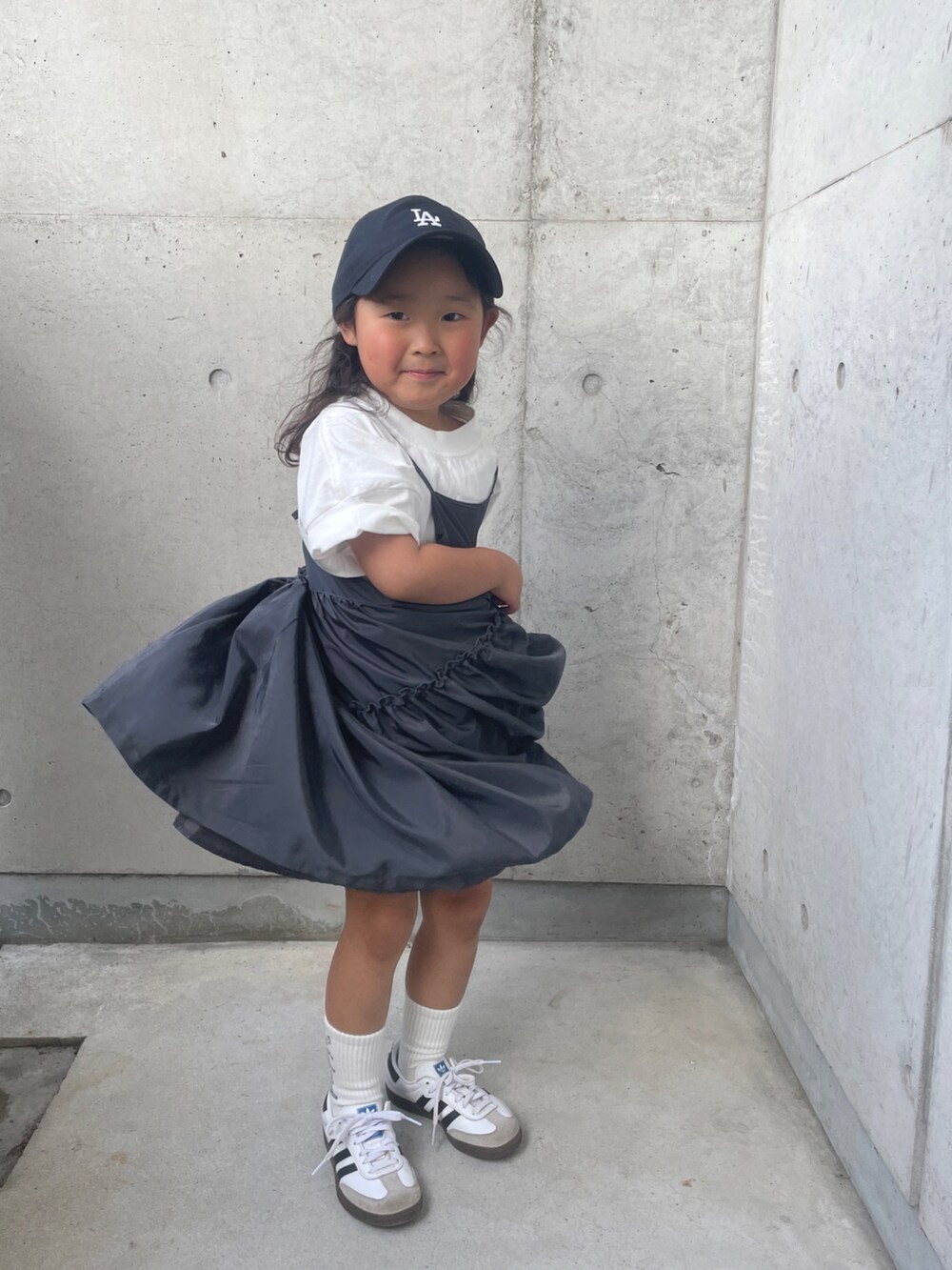 ホワイト系のスニーカー、グレー系のワンピース、ホワイト系のTシャツ/カットソーを着用したキッズの春コーディネートの3枚目の写真