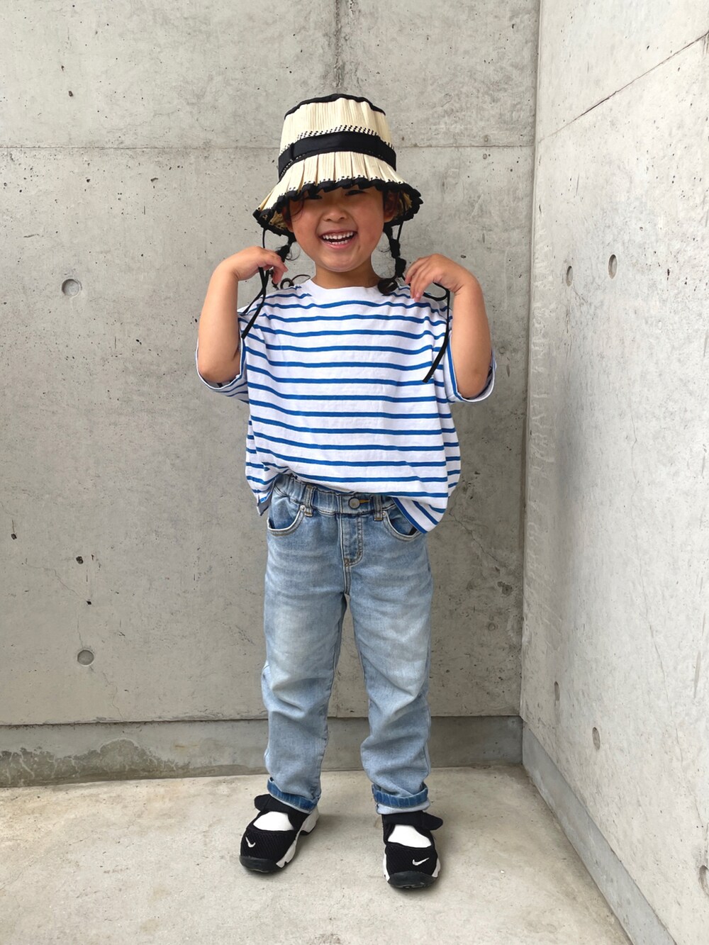 ブルー系のTシャツ/カットソー、ブラック系のスニーカー、ブルー系のデニムパンツを着用したキッズの春コーディネートの3枚目の写真