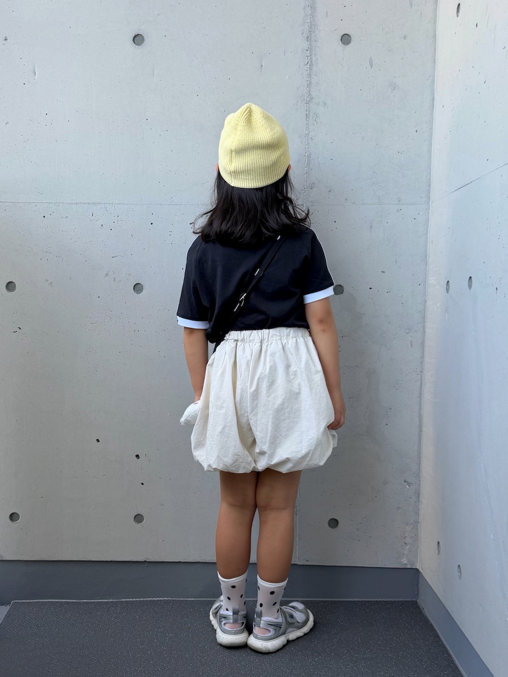 シルバー系のスニーカー、ブラック系のショルダーバッグ、ホワイト系のその他パンツを着用したキッズの夏コーディネートの3枚目の写真