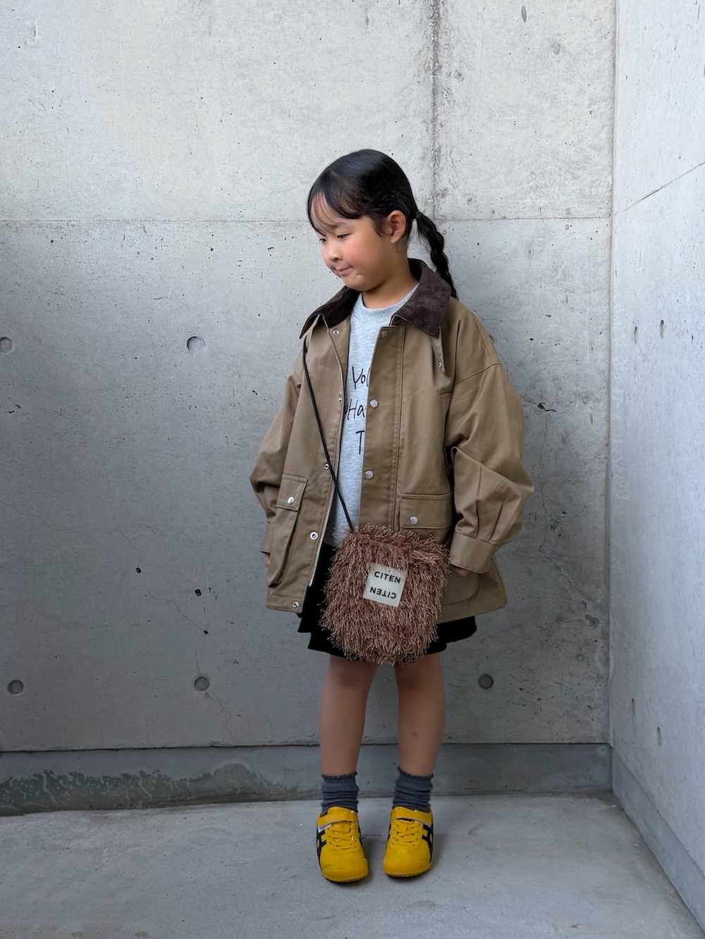 グレー系のTシャツ/カットソー、ベージュ系のミリタリージャケット、イエロー系のスニーカーを着用したキッズの秋コーディネートの2枚目の写真