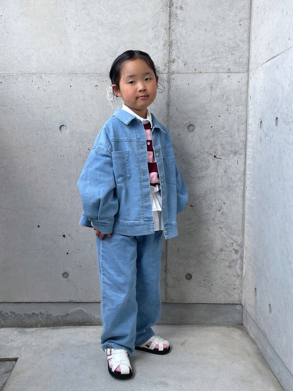 ブルー系のデニムジャケット、ブルー系のデニムパンツ、ピンク系のTシャツ/カットソーを着用したキッズの春コーディネートの3枚目の写真