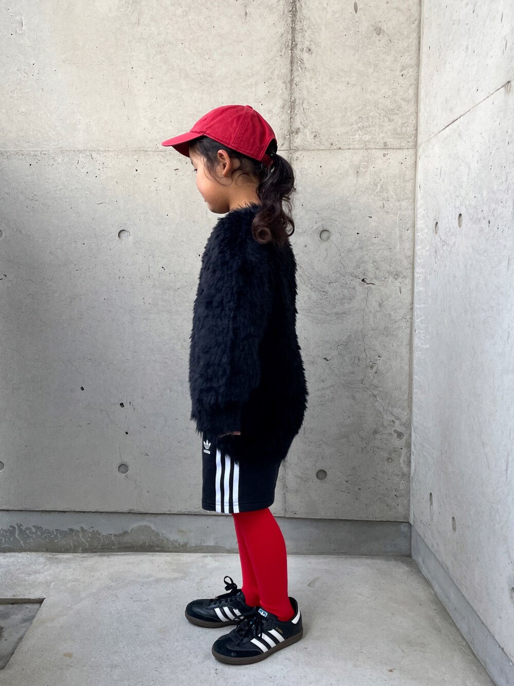 ブラック系のニット/セーター、ホワイト系のTシャツ/カットソー、ブラック系のその他パンツを着用したキッズの冬コーディネートの3枚目の写真