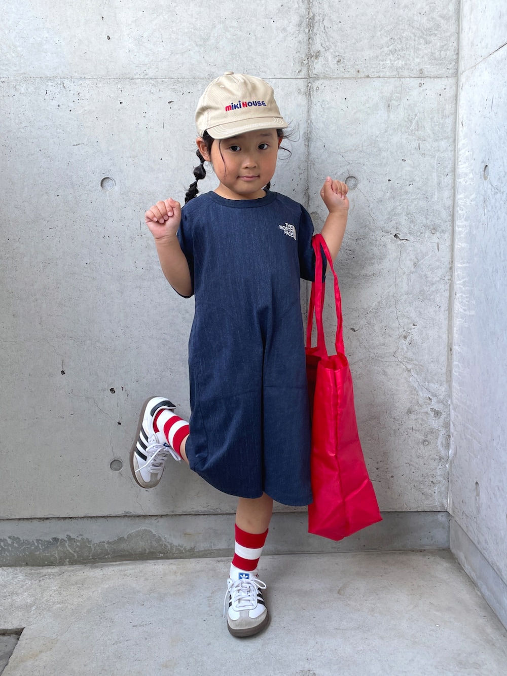 ホワイト系のスニーカー、レッド系のバッグ、ブルー系のワンピースを着用したキッズの春コーディネートの2枚目の写真