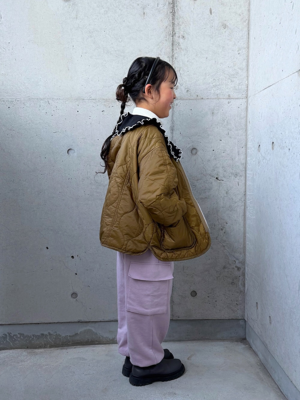 ブラック系のスウェット、ピンク系のカーゴパンツ、グレー系のブーツを着用したキッズの冬コーディネートの4枚目の写真