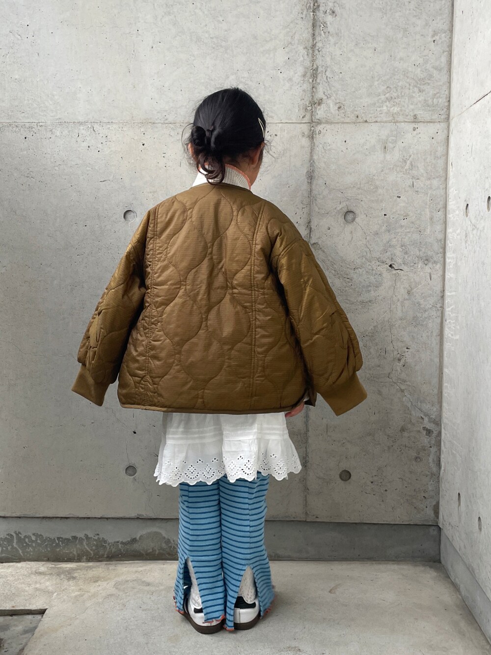 ブラウン系のダウンジャケット/コート、ホワイト系のパンツ、グレー系のスウェットを着用したキッズの春コーディネートの2枚目の写真