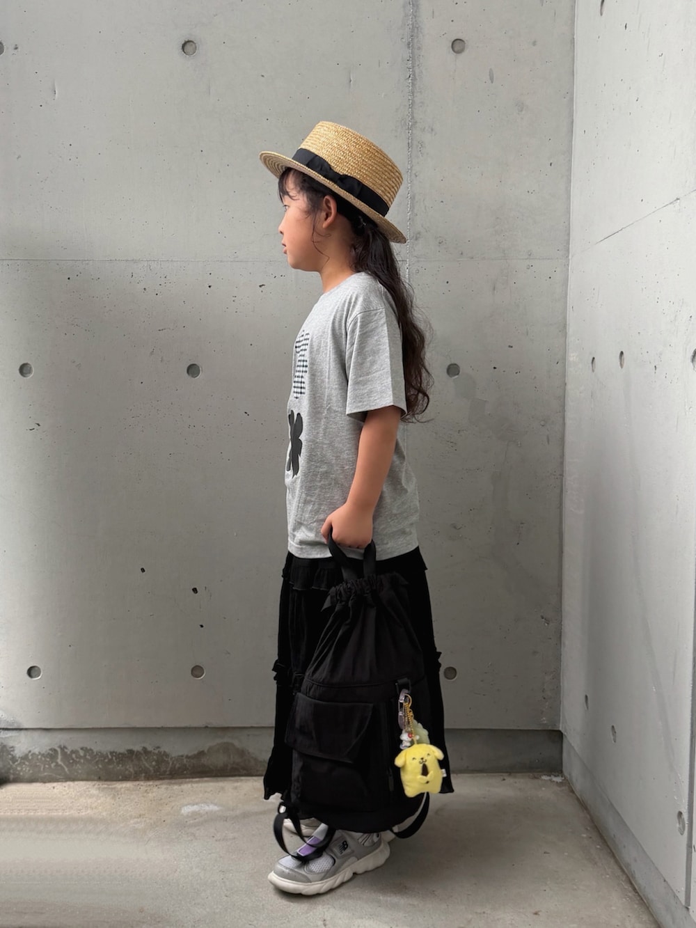 ブラック系のスカート、ブラック系のバックパック/リュック、シルバー系のスニーカーを着用したキッズの夏コーディネートの2枚目の写真