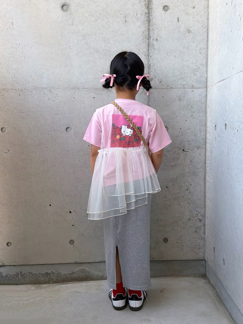 ホワイト系のTシャツ/カットソー、グレー系のスカート、ベージュ系のショルダーバッグを着用したキッズの春コーディネートの2枚目の写真