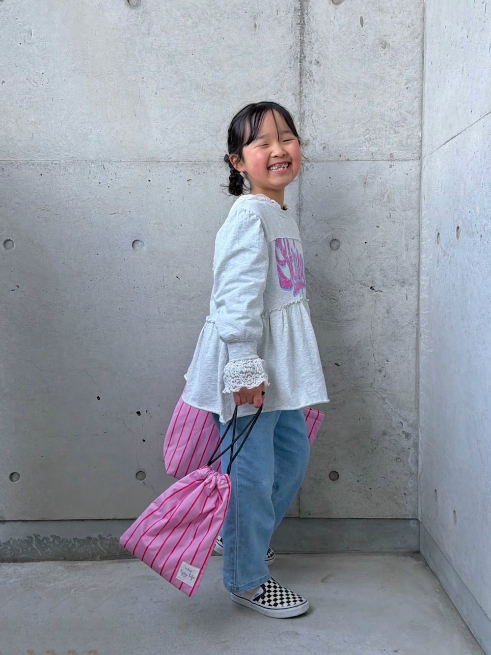 ホワイト系のTシャツ/カットソー、グレー系のワンピース、ピンク系のトートバッグを着用したキッズの冬コーディネートの2枚目の写真