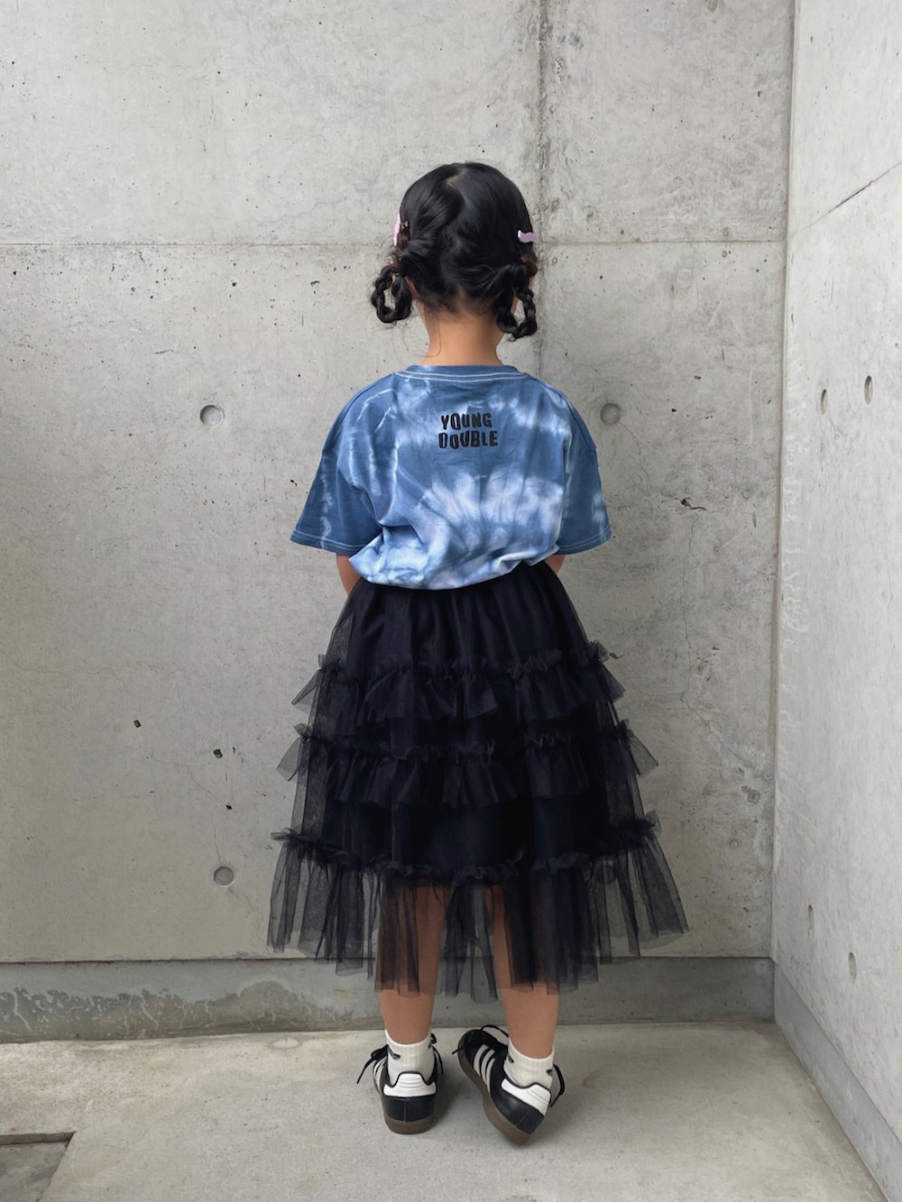ブラック系のスカート、ブラック系のスニーカー、ブルー系のTシャツ/カットソーを着用したキッズの春コーディネートの3枚目の写真