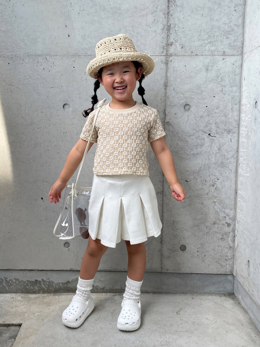 ベージュ系のトップス、ブラック系のスカート、ホワイト系のサンダルを着用したキッズの夏コーディネートの5枚目の写真