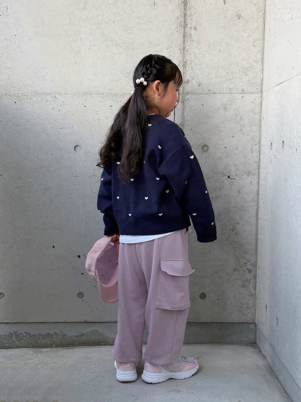ピンク系のカーゴパンツ、ピンク系のスニーカー、ブルー系のニット/セーターを着用したキッズの冬コーディネートの2枚目の写真