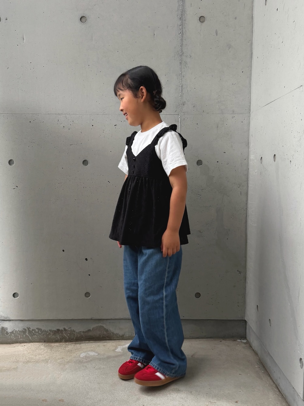 ブラック系のセットアップ、レッド系のスニーカー、ブルー系のデニムパンツを着用したキッズの夏コーディネートの2枚目の写真