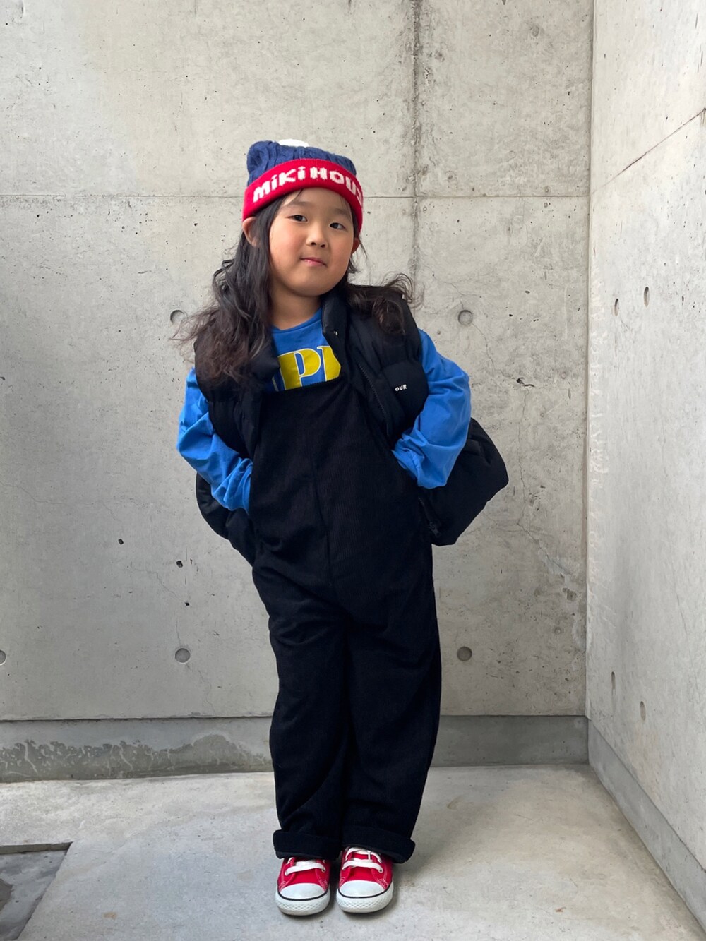 ブラック系のダウンベスト、ブルー系のTシャツ/カットソー、ブラック系のサロペット/オーバーオールを着用したキッズの冬コーディネートの4枚目の写真