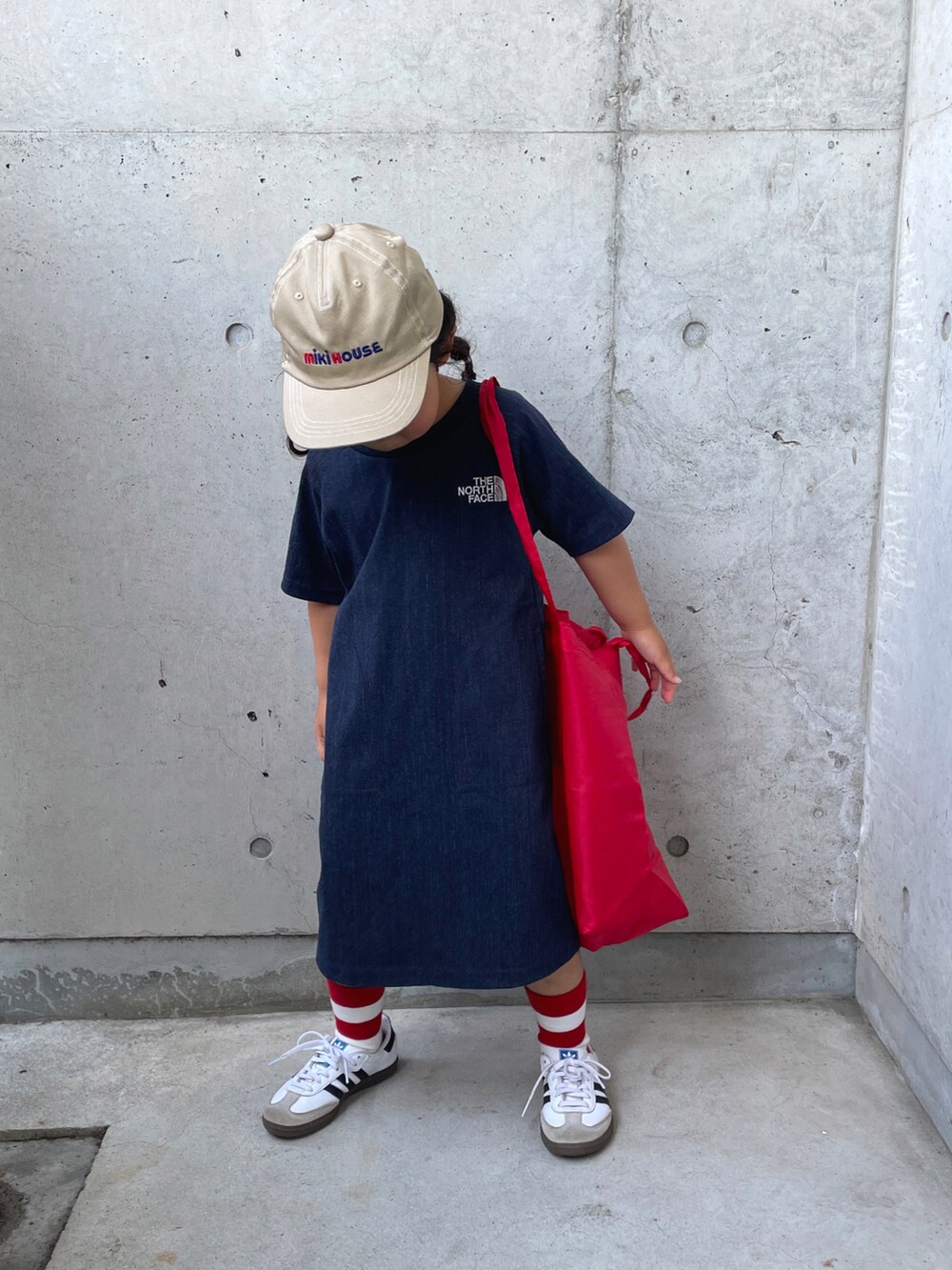 ホワイト系のスニーカー、レッド系のバッグ、ブルー系のワンピースを着用したキッズの春コーディネートの4枚目の写真