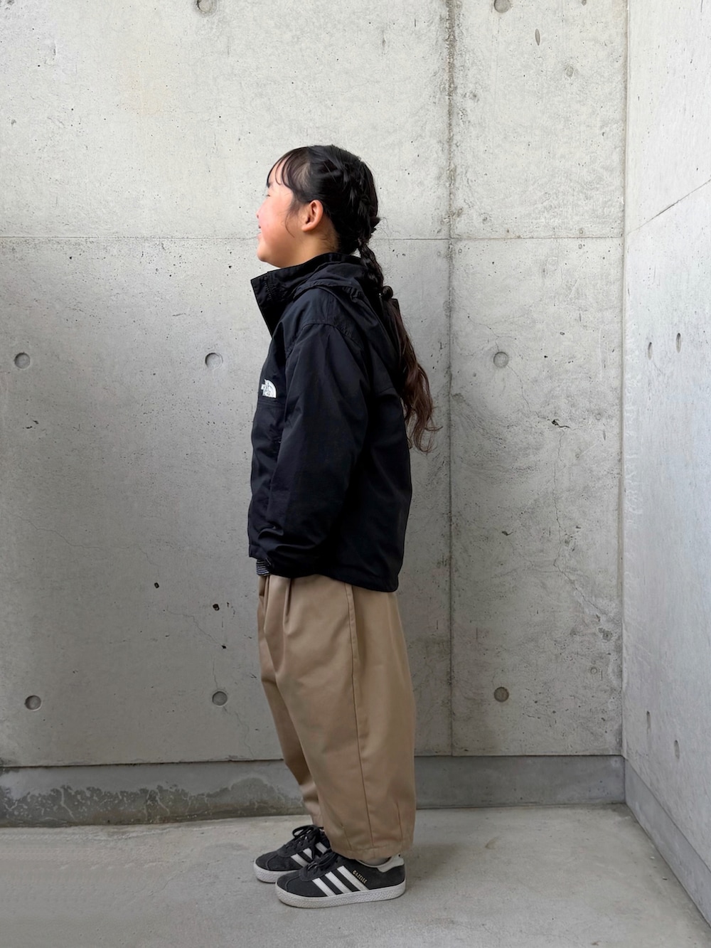 ブラック系のTシャツ/カットソー、ブラック系のマウンテンパーカー、イエロー系のその他パンツを着用したキッズの春コーディネートの2枚目の写真