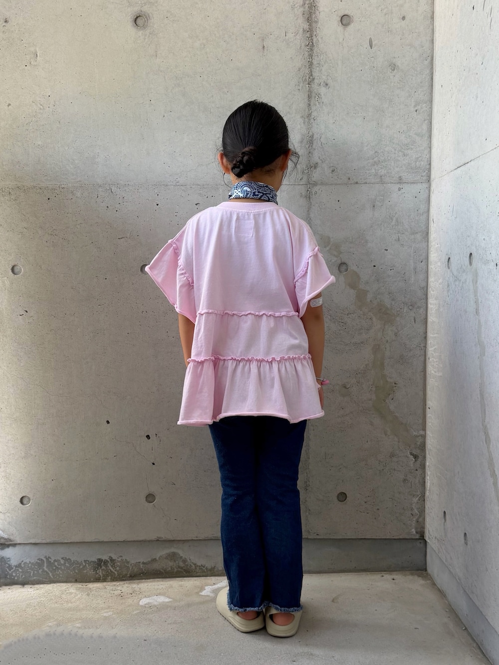 ピンク系のTシャツ/カットソー、ベージュ系のサンダル、ブルー系のデニムパンツを着用したキッズの夏コーディネートの4枚目の写真