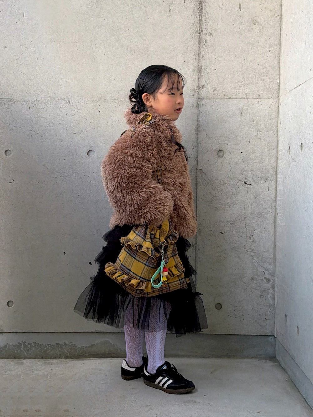 イエロー系のバックパック/リュック、ブラック系のスニーカー、レッド系のニット/セーターを着用したキッズの冬コーディネートの4枚目の写真