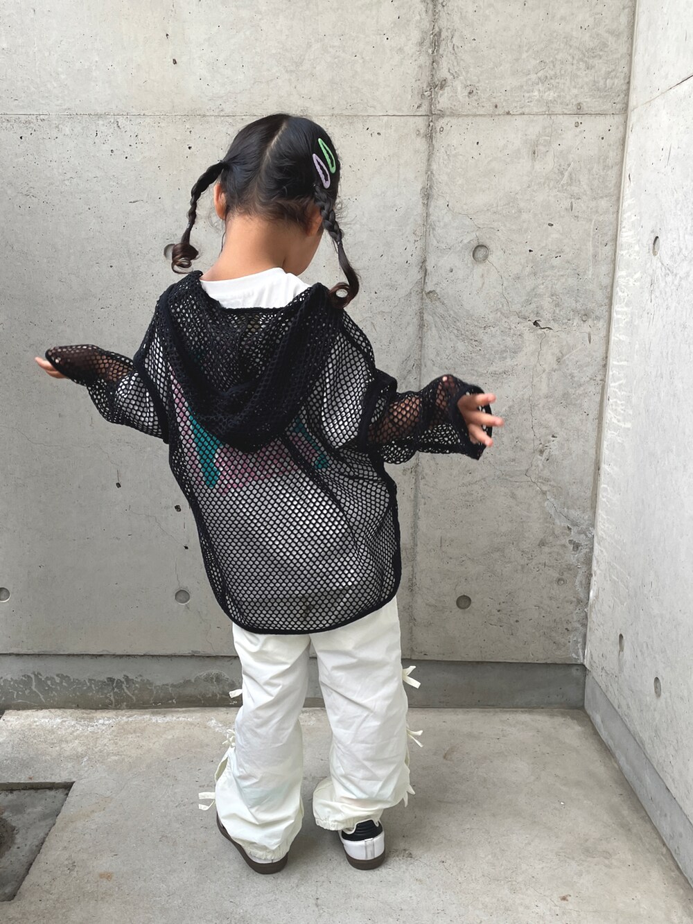 ブラック系のトップス、ホワイト系のその他パンツ、ホワイト系のスニーカーを着用したキッズの春コーディネートの3枚目の写真