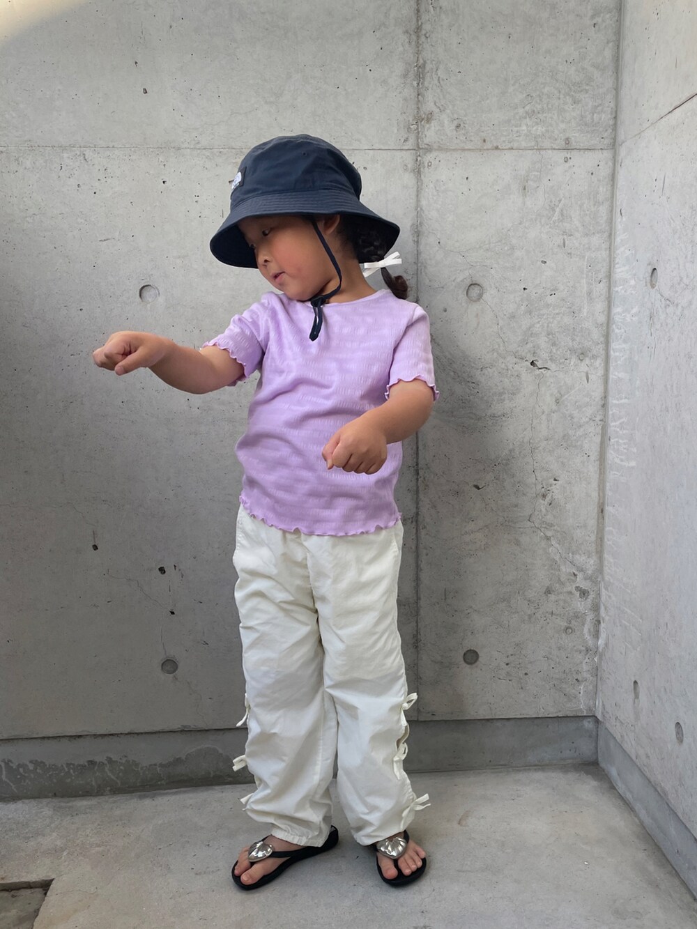 パープル系のTシャツ/カットソー、ホワイト系のその他パンツ、ブラック系のサンダルを着用したキッズの春コーディネートの4枚目の写真