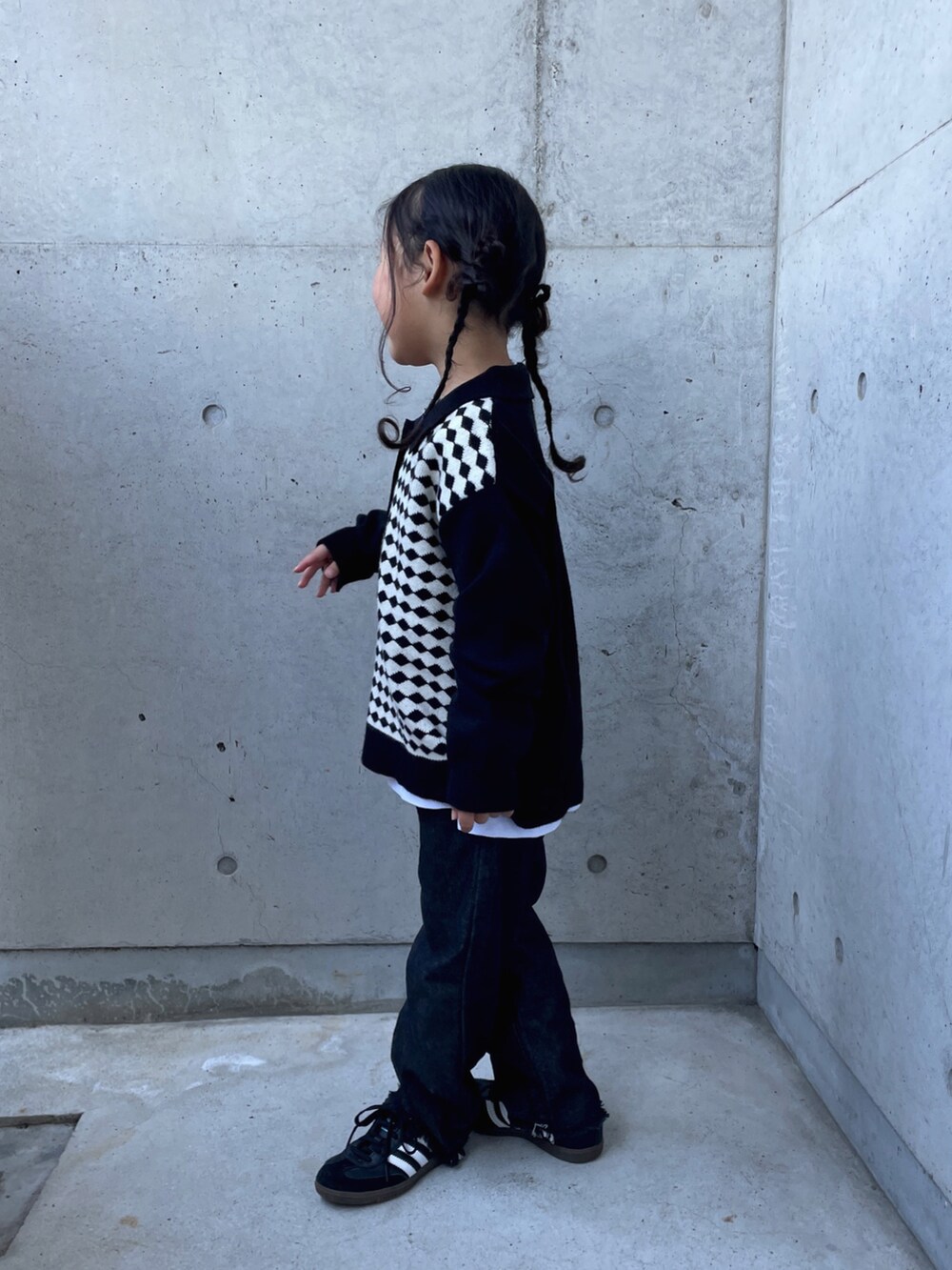 ブラック系のパンツ、ブラック系のニット/セーター、ホワイト系のTシャツ/カットソーを着用したキッズの秋コーディネートの4枚目の写真