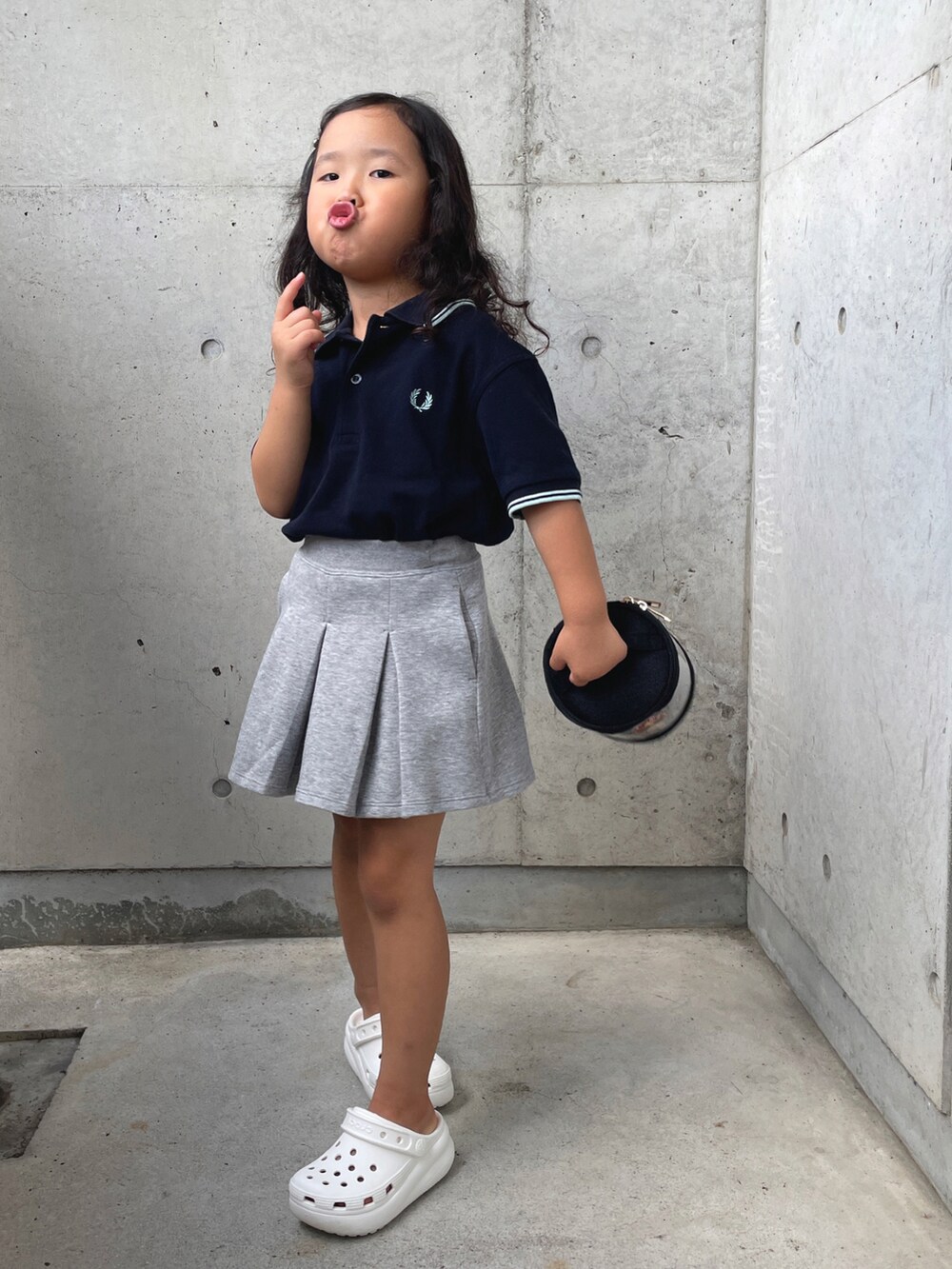 ホワイト系のサンダル、ブルー系のポロシャツ、グレー系のスカートを着用したキッズの夏コーディネートの5枚目の写真
