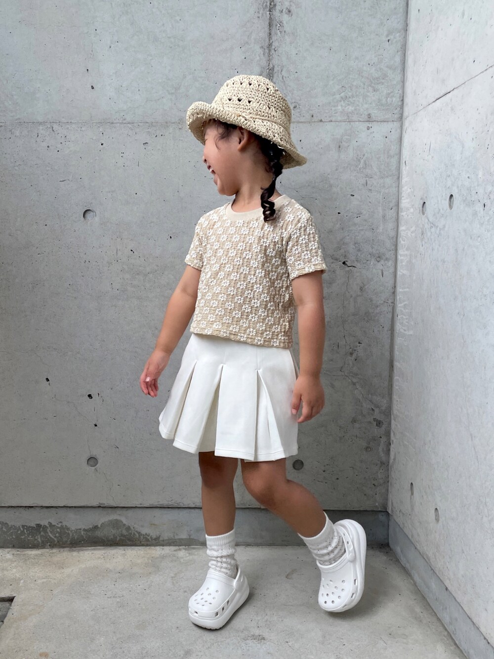 ベージュ系のトップス、ブラック系のスカート、ホワイト系のサンダルを着用したキッズの夏コーディネートの4枚目の写真