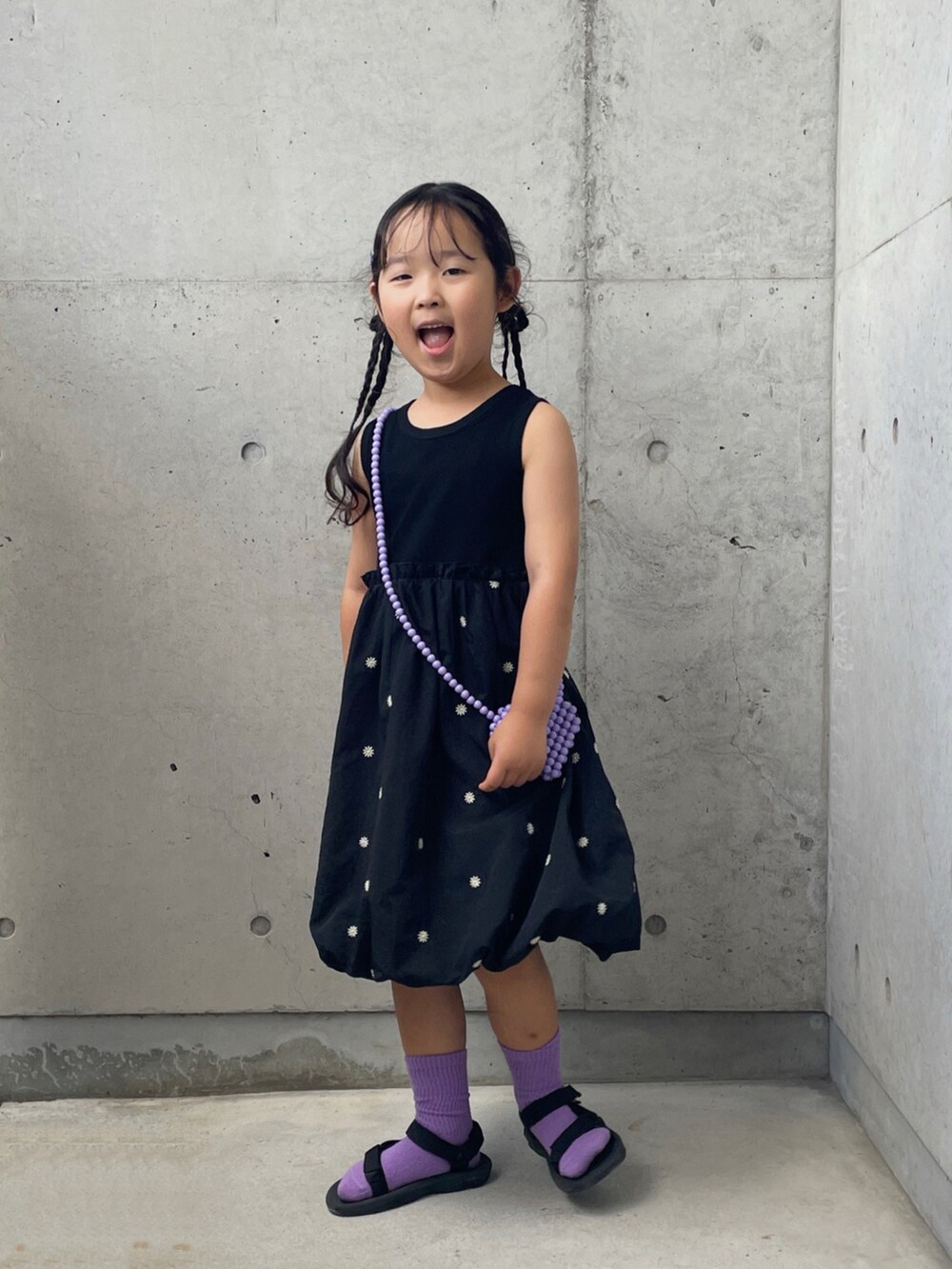 ブラック系のサンダル、ブラック系のワンピース、パープル系のソックス/靴下を着用したキッズの夏コーディネートの3枚目の写真