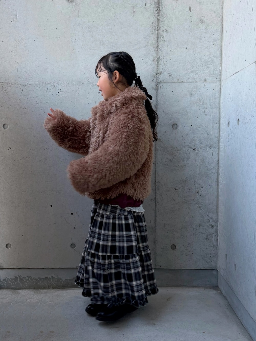 ブラウン系のブルゾン、ブラウン系のスカート、レッド系のスウェットを着用したキッズの冬コーディネートの2枚目の写真