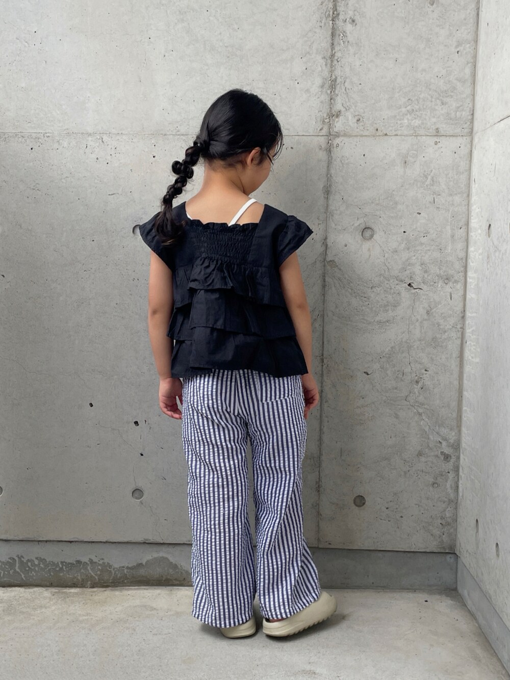 ホワイト系のキャミソール、ベージュ系のサンダル、ブラック系のシャツ/ブラウスを着用したキッズの夏コーディネートの3枚目の写真