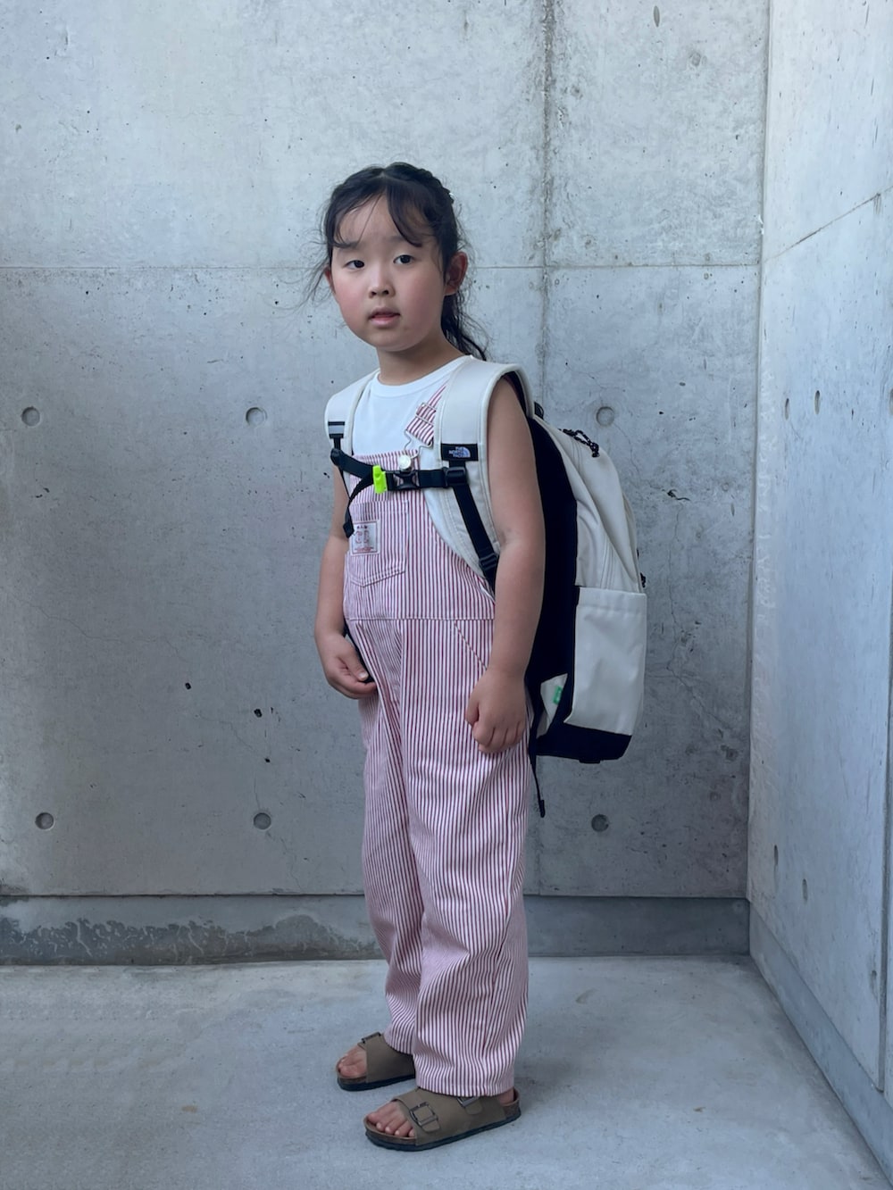 ホワイト系のシャツ/ブラウス、レッド系のオールインワン・サロペット、ホワイト系のバックパック/リュックを着用したキッズの秋コーディネートの5枚目の写真