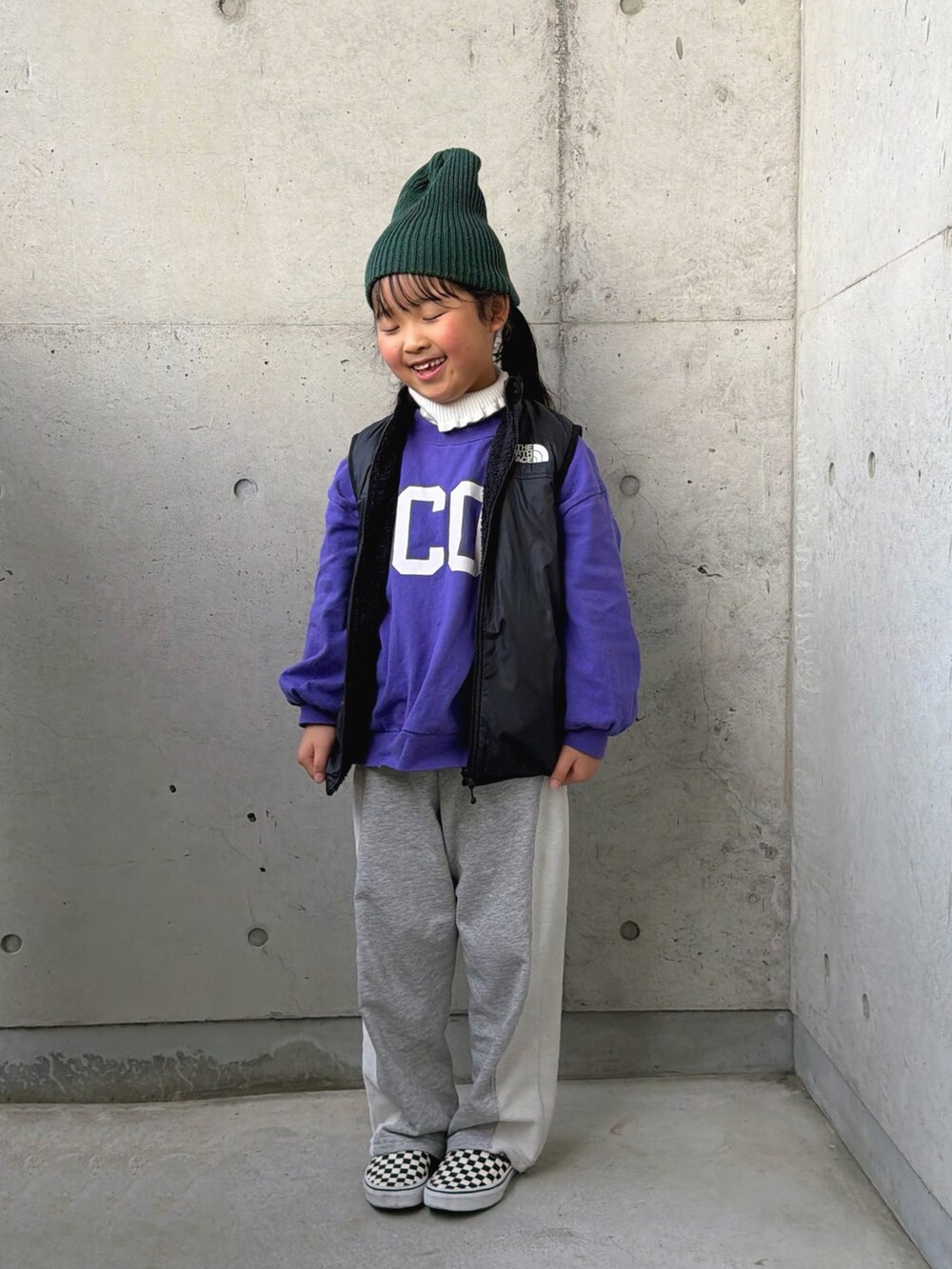 パープル系のTシャツ/カットソー、グレー系のスウェットパンツ、ブラック系のベストを着用したキッズの冬コーディネートの2枚目の写真