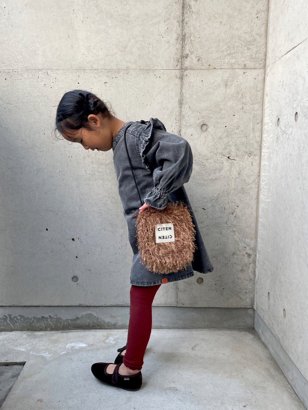 ブラウン系のショルダーバッグ、ブラウン系のバレエシューズ、ベージュ系のダッフルコートを着用したキッズの秋コーディネートの4枚目の写真