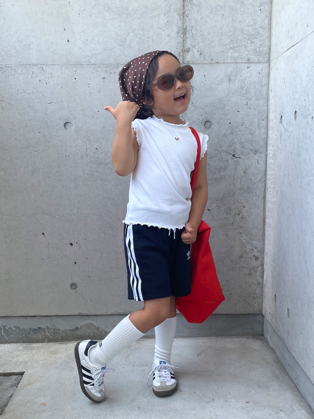 ブラック系のその他パンツ、ホワイト系のスニーカー、オレンジ系のトートバッグを着用したキッズの夏コーディネートの2枚目の写真