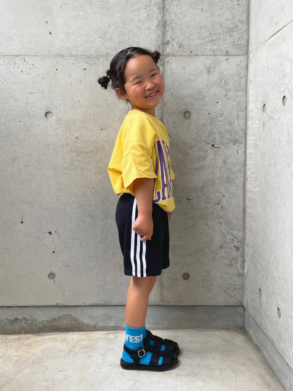 イエロー系のTシャツ/カットソー、ブラック系のその他パンツ、ブラック系のサンダルを着用したキッズの春コーディネートの4枚目の写真