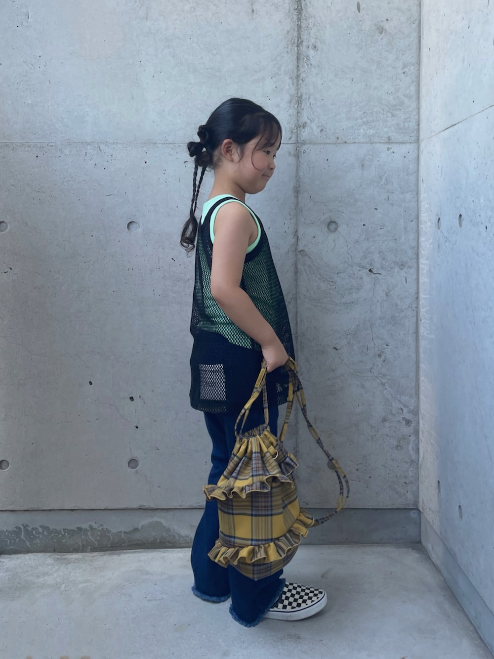 ブラック系のタンクトップ、ブルー系のデニムパンツ、イエロー系のバックパック/リュックを着用したキッズの夏コーディネートの2枚目の写真