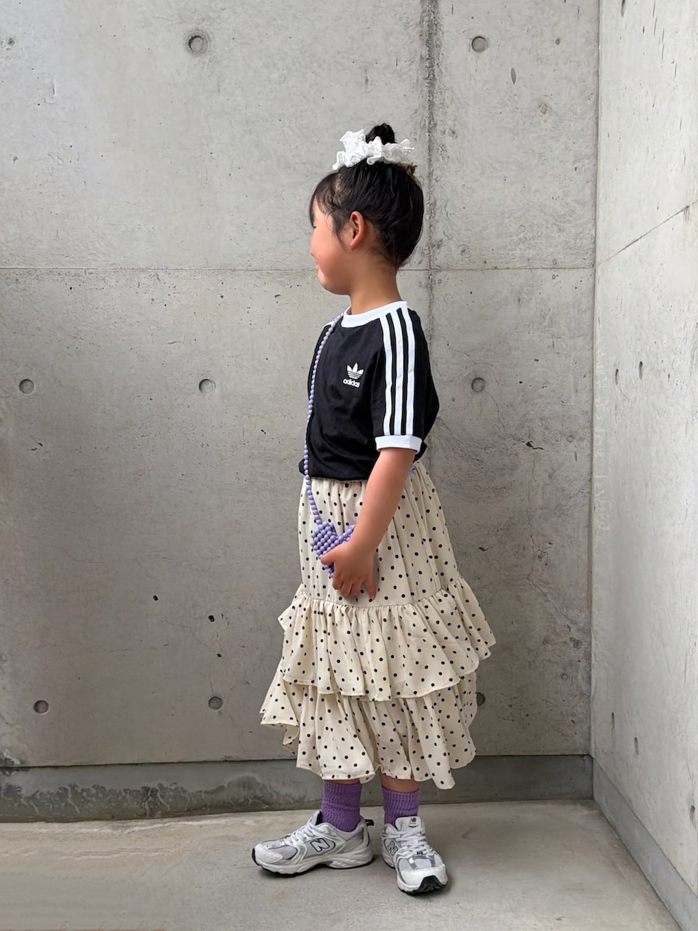 ホワイト系のスカート、ホワイト系のスニーカー、ブラック系のTシャツ/カットソーを着用したキッズの春コーディネートの2枚目の写真
