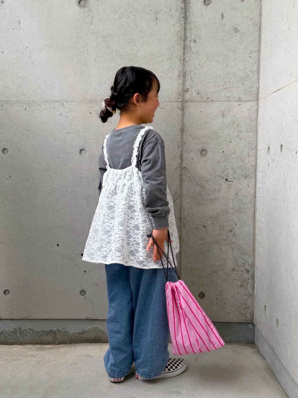 ピンク系のトートバッグ、ブラック系のスリッポン、ホワイト系のトップスを着用したキッズの春コーディネートの2枚目の写真