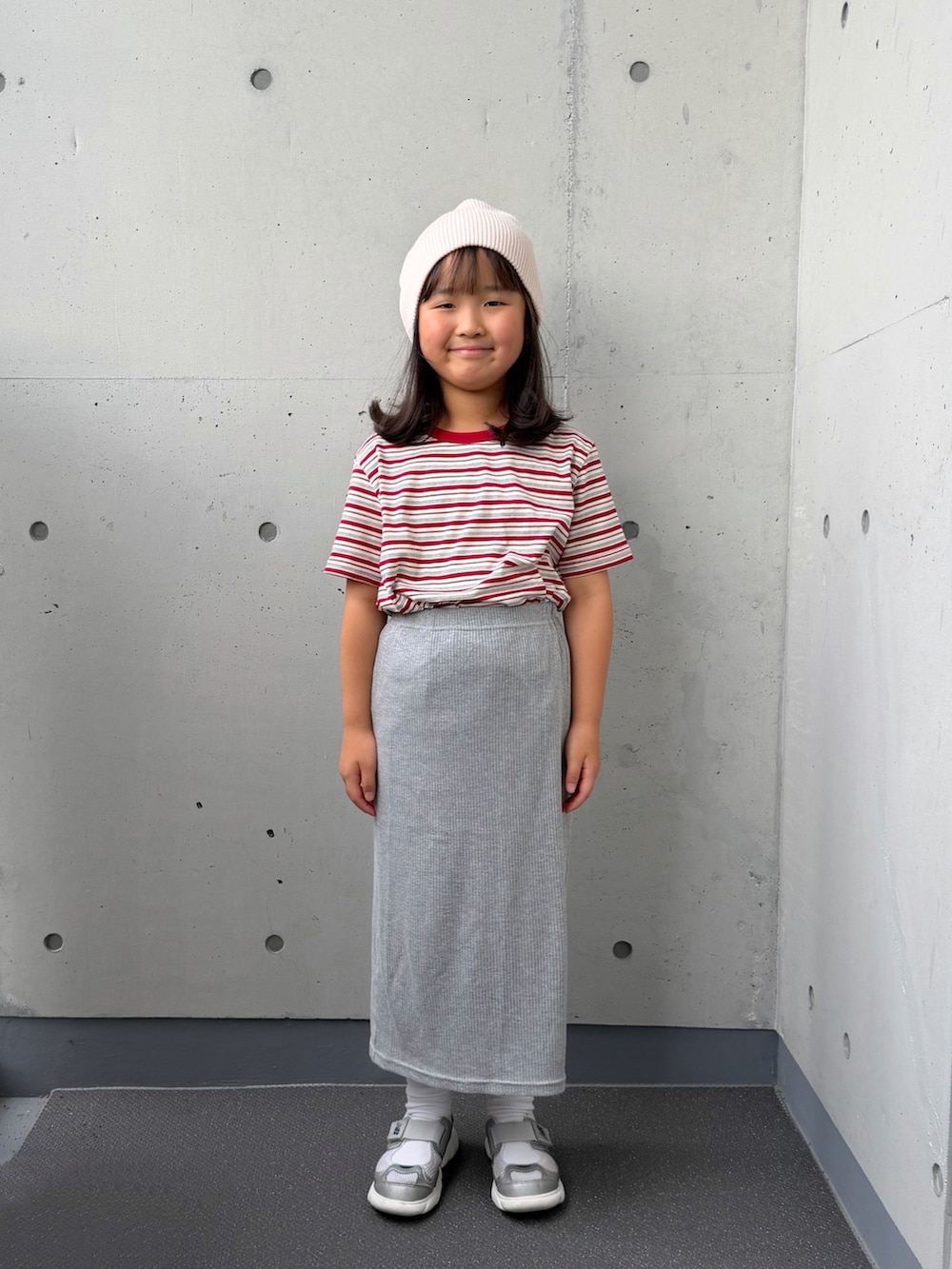 ホワイト系のTシャツ/カットソー、グレー系のスカート、シルバー系のスニーカーを着用したキッズの秋コーディネートの3枚目の写真